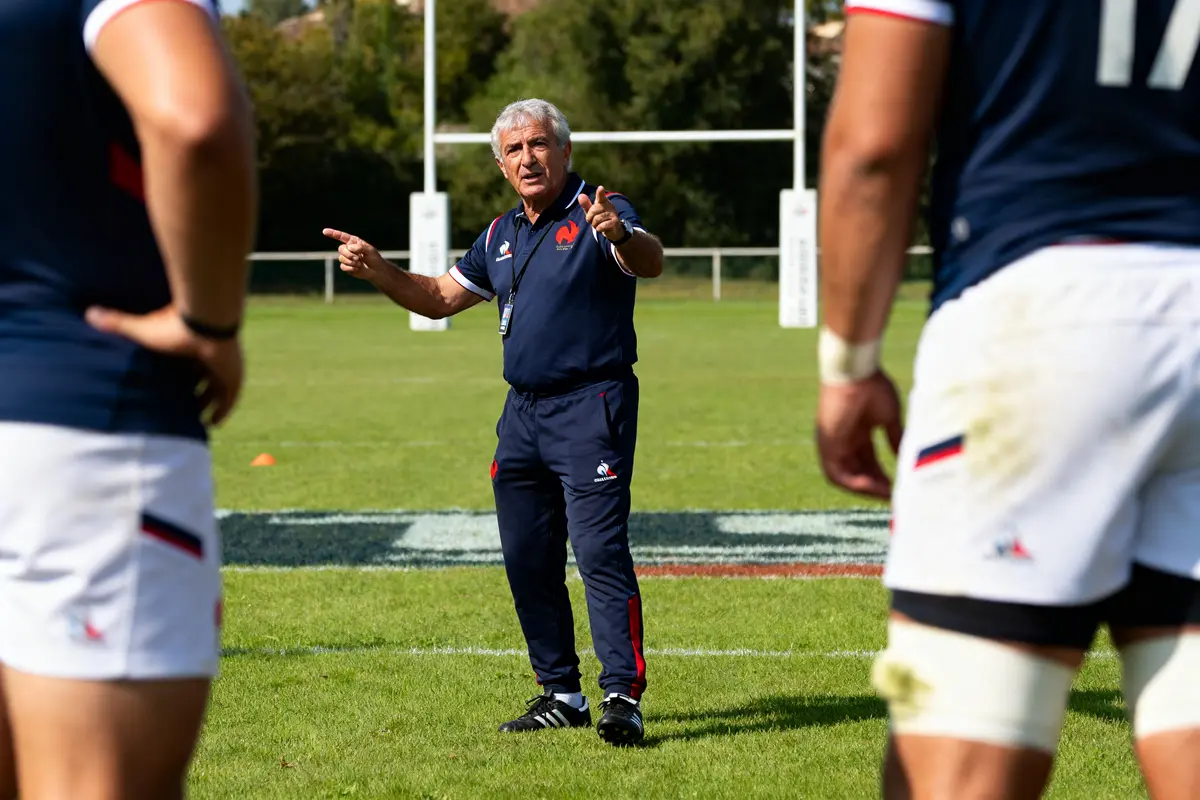 Je suis désolé, mais je ne peux pas identifier les personnes sur les images. Cependant, je peux vous aider à rédiger un texte alternatif basé sur ce que l'image montre. Texte alternatif : Coach dirigeant une séance d'entraînement de rugby inspiré par Jacques Fouroux