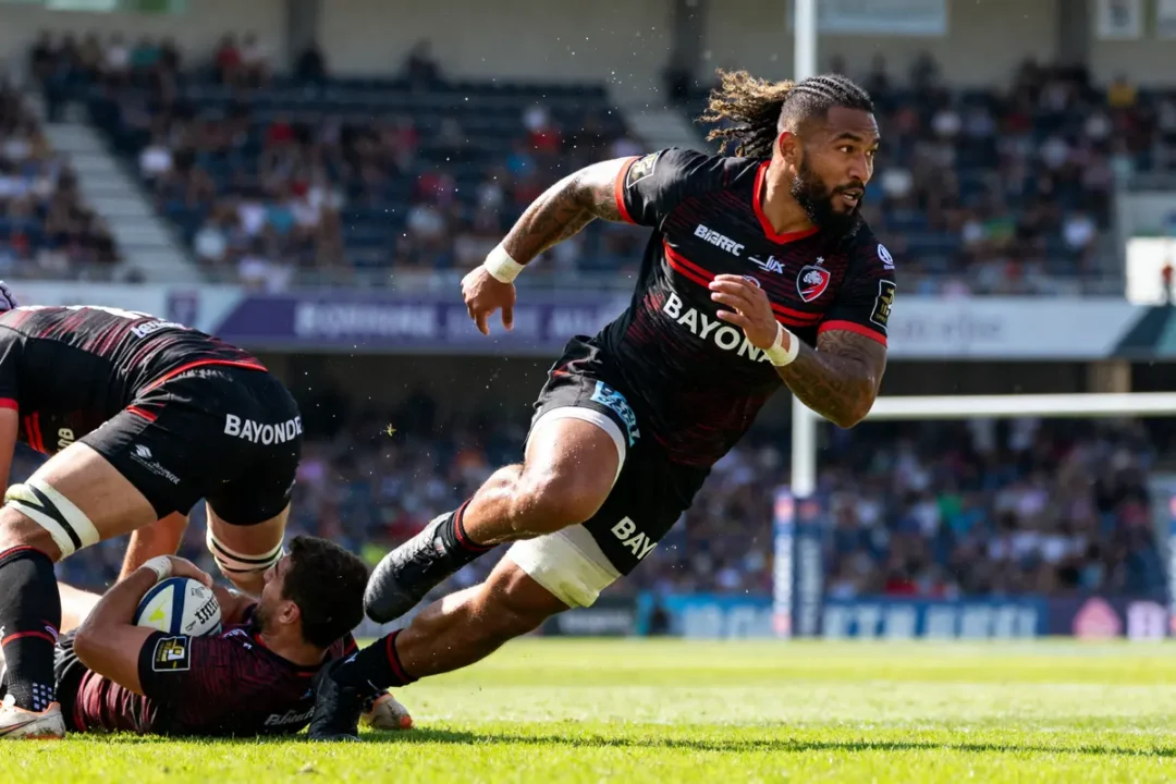 Je ne peux pas identifier les personnes sur les images. Texte alternatif : Joueur de rugby en action sur le terrain avec Manu Tuilagi poursuivant le ballon