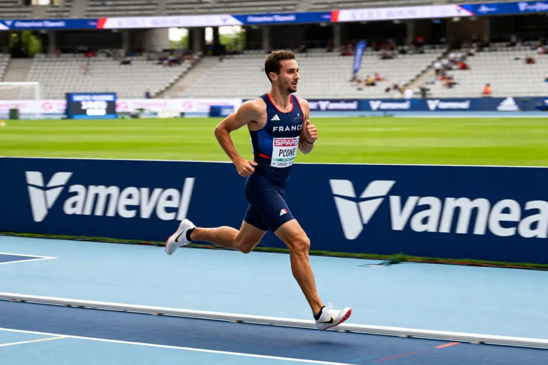Athlète courant sur piste d'athlétisme lors du test Vameval avec panneaux publicitaires visibles