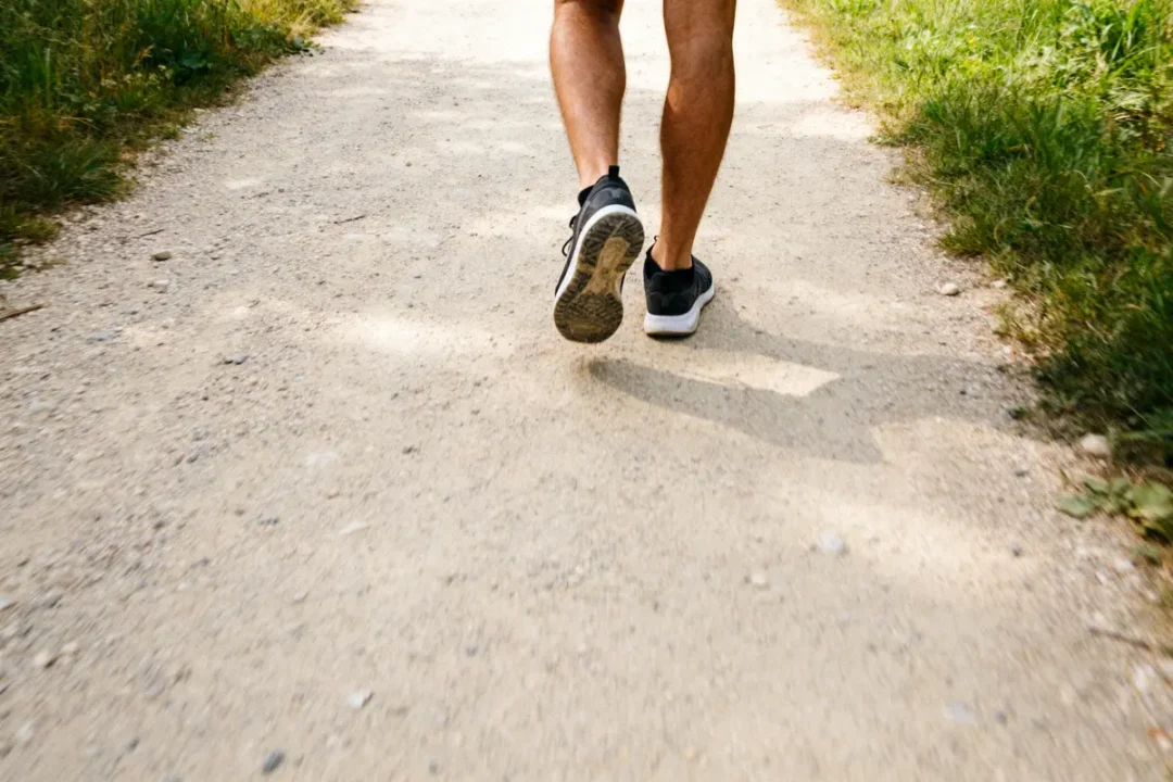 Personne marchant sur sentier, illustrant 20000 pas en km durant une promenade active