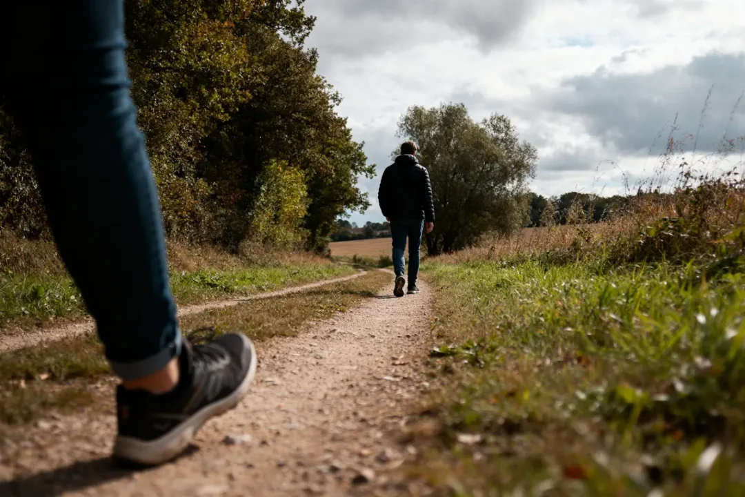 Deux personnes marchant sur un sentier naturel illustrant 20000 pas en km quotidiennement