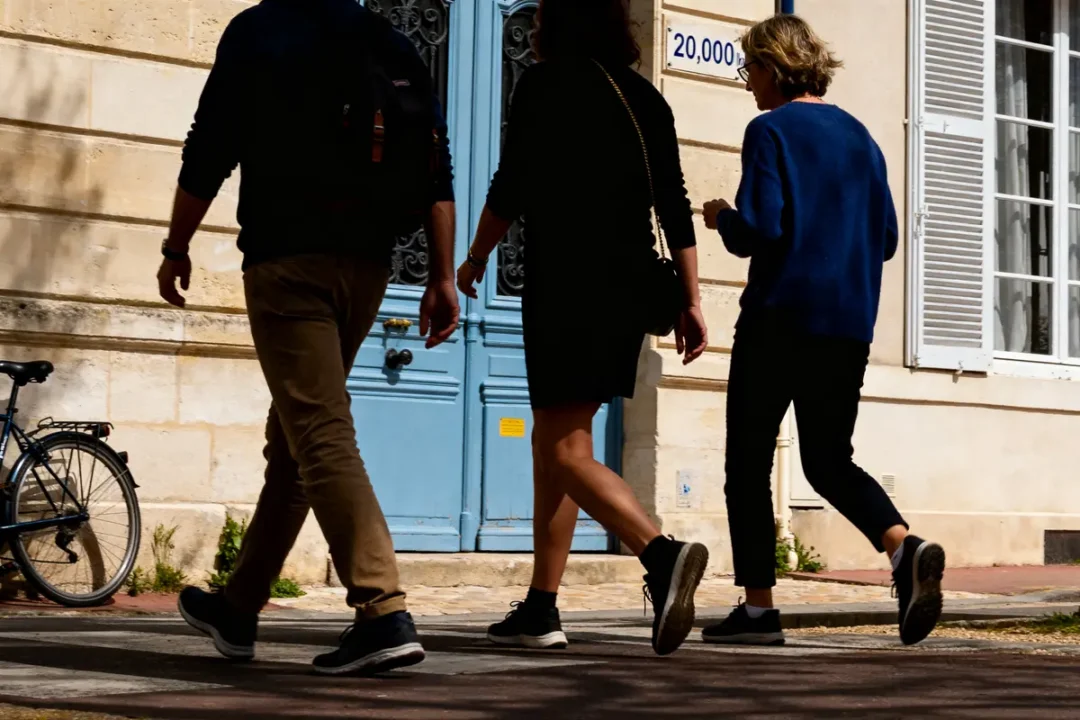Trois personnes marchant devant une porte bleue pour atteindre 20000 pas en km