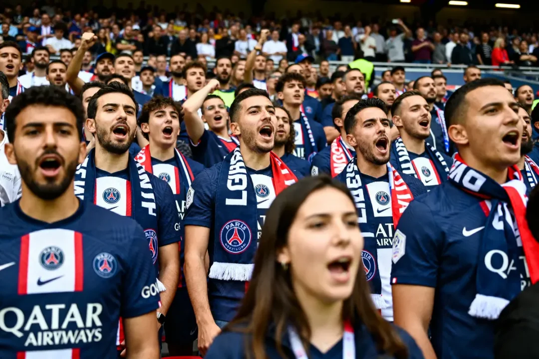 Supporters du PSG chantant en tribunes, passion et ambiance captivante dzfoot