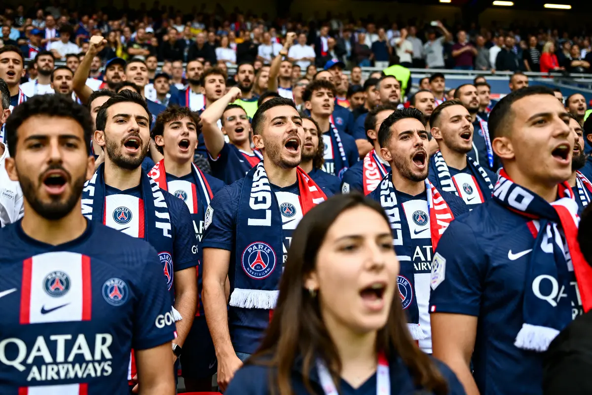 Supporters du PSG chantant en tribunes, passion et ambiance captivante dzfoot