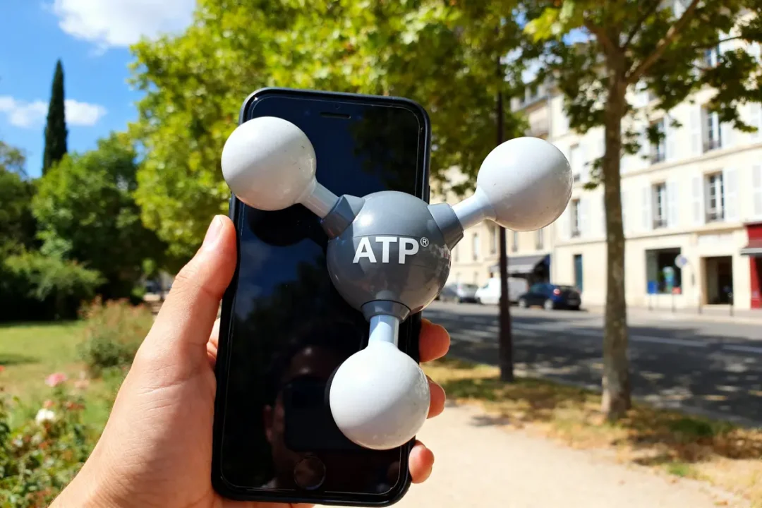 Main tenant téléphone avec modèle mol ATP en plein air par une journée ensoleillée