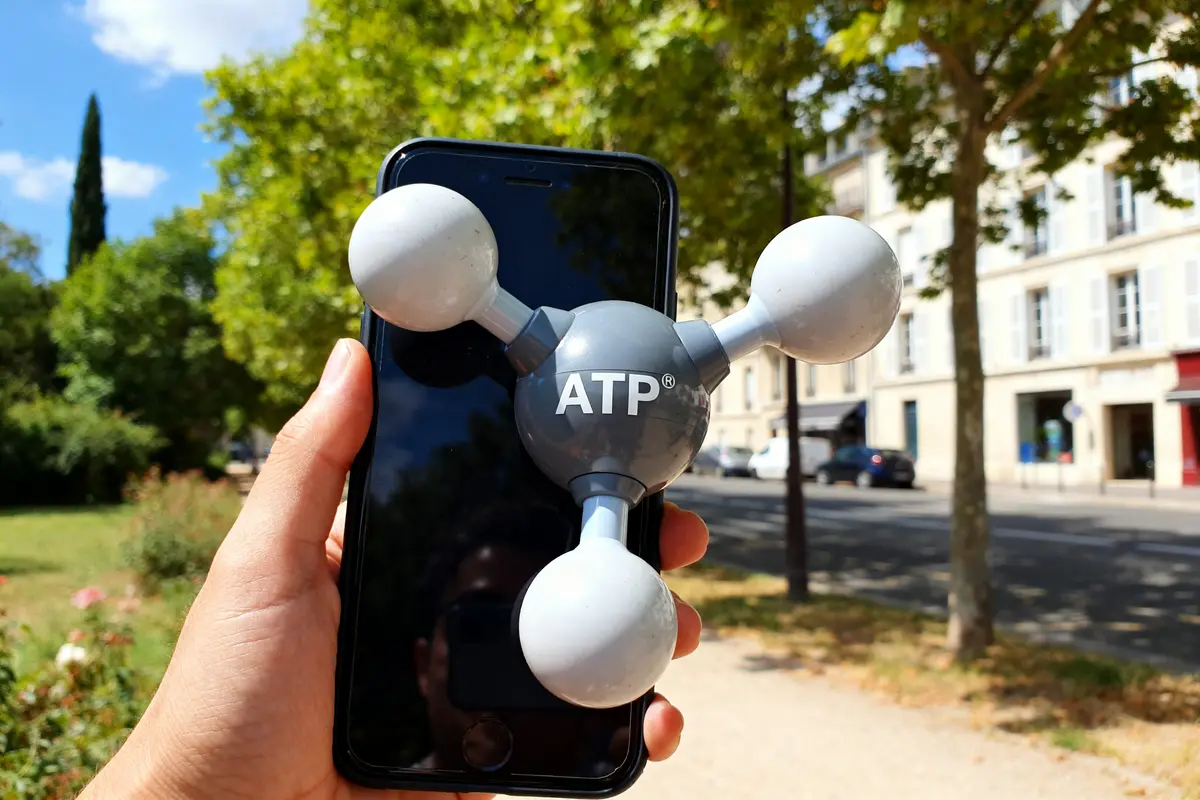 Main tenant téléphone avec modèle mol ATP en plein air par une journée ensoleillée