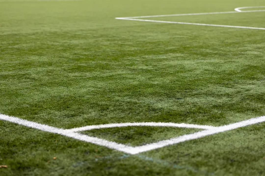 Angle du terrain de foot montrant les lignes blanches et distance terrain de foot