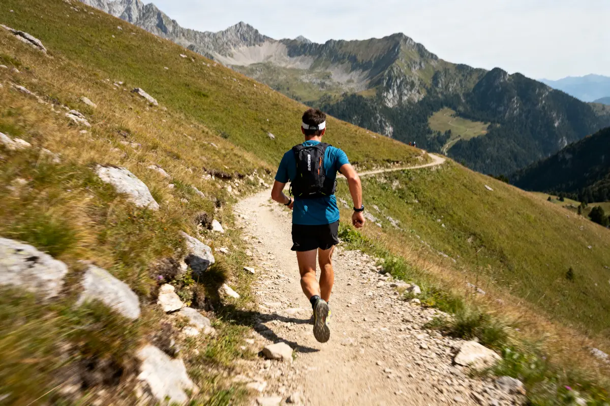 Homme courant sur sentier de montagne, parfait pour entraĂźnement pour le trail en plein air