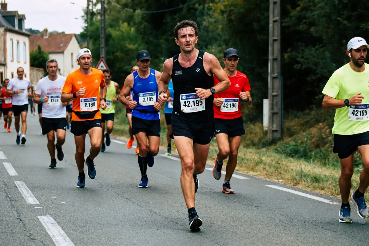 Des coureurs sur route durant un marathon dont la distance est de 42 km