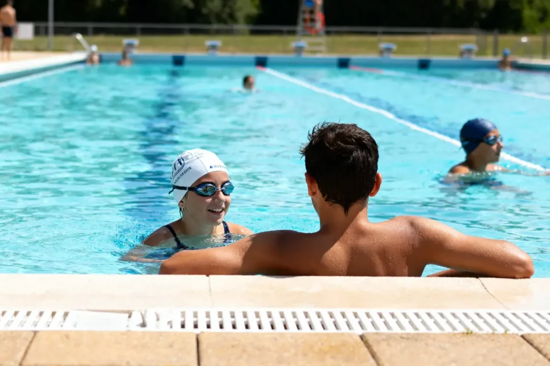 Personnes nageant et discutant à la piscine du stade nautique de Caen