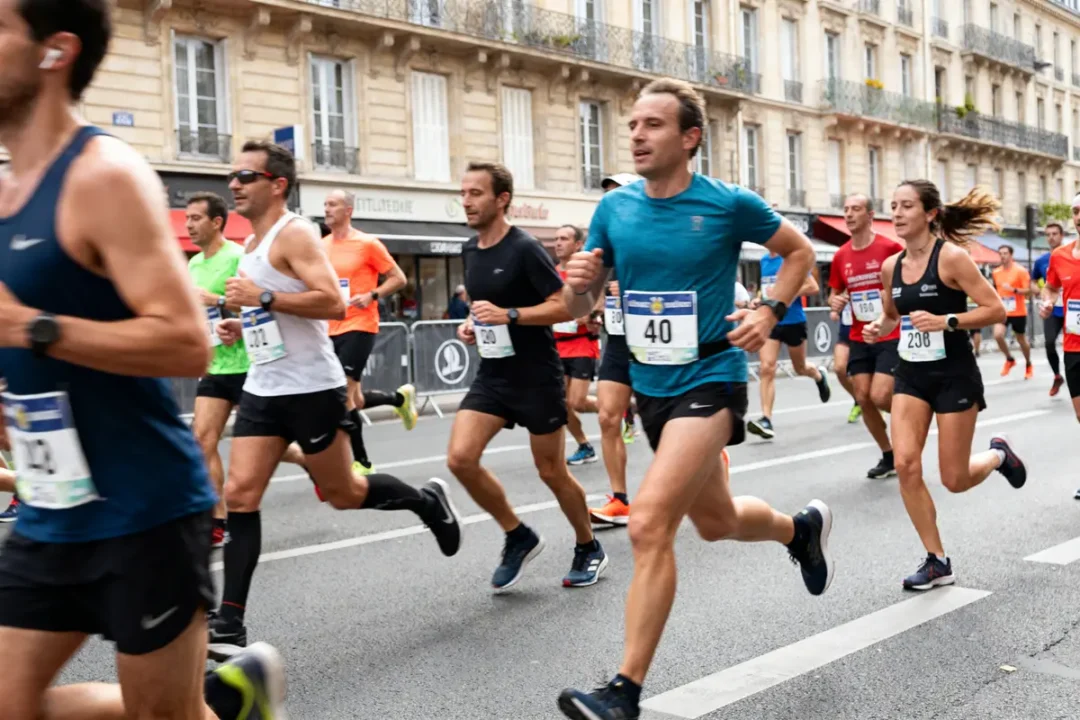 Coureurs en plein effort pendant une course sur route, visant leur meilleur temps marathon